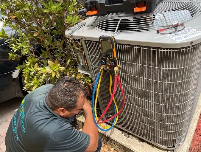 Comfactor Air technician using gauges and hoses on an A/C system